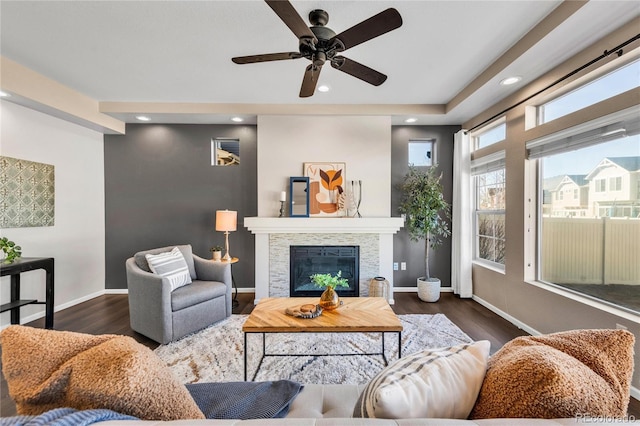 living room with ceiling fan, a fireplace, and dark hardwood / wood-style floors