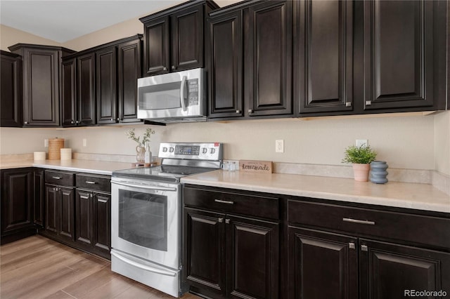 kitchen with appliances with stainless steel finishes and light hardwood / wood-style flooring