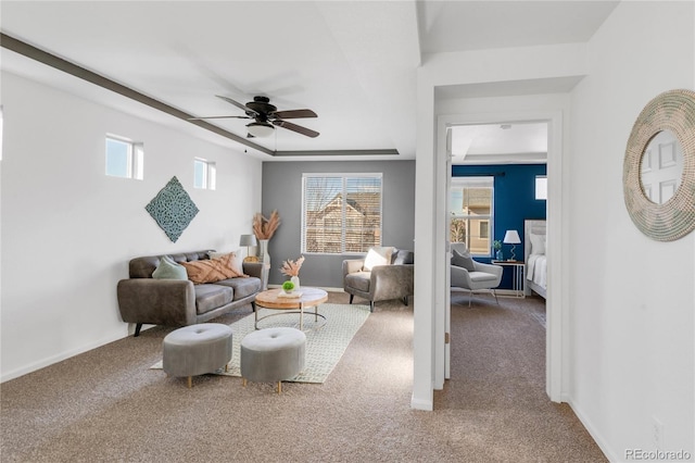 living room with carpet flooring, ceiling fan, a healthy amount of sunlight, and a raised ceiling