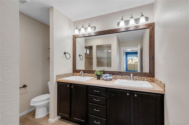 bathroom with tile patterned flooring, vanity, and toilet