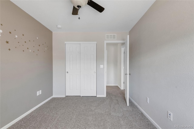 unfurnished bedroom with ceiling fan, a closet, and carpet floors