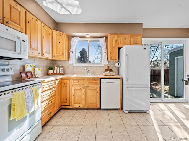 kitchen with white appliances, a wealth of natural light, sink, and light brown cabinets