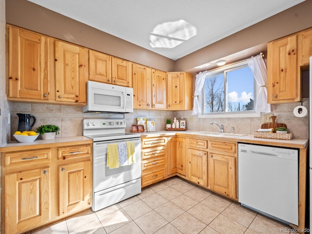 kitchen featuring sink, light brown cabinets, backsplash, and white appliances