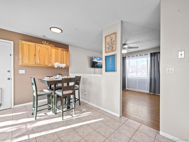 tiled dining area featuring a textured ceiling and ceiling fan