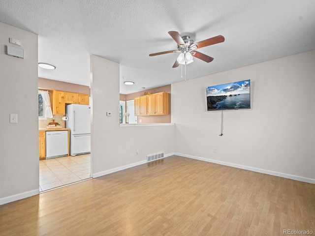 unfurnished living room with ceiling fan, a textured ceiling, and light wood-type flooring