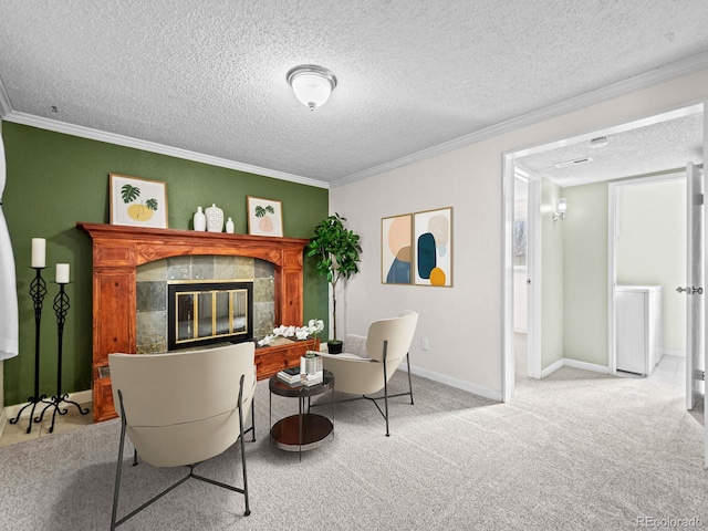 sitting room featuring a tiled fireplace, ornamental molding, carpet floors, and a textured ceiling