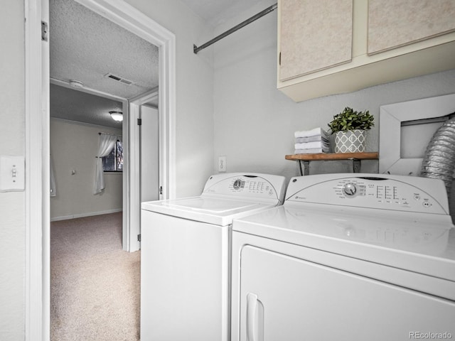 laundry room with cabinets, independent washer and dryer, carpet, and a textured ceiling