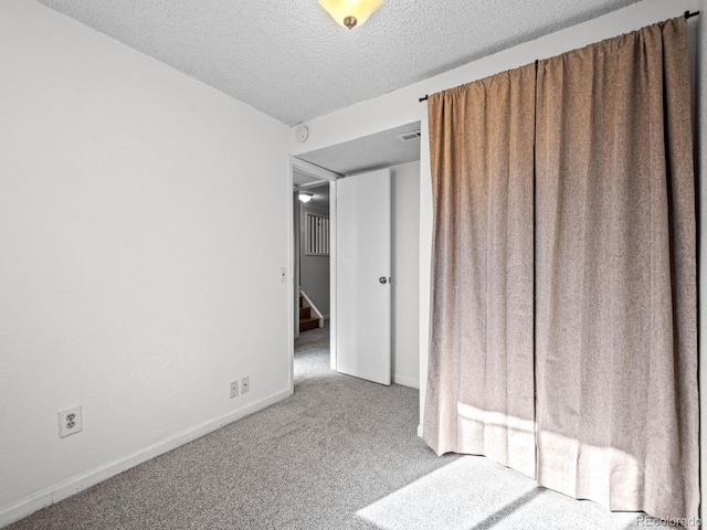 spare room with carpet floors and a textured ceiling