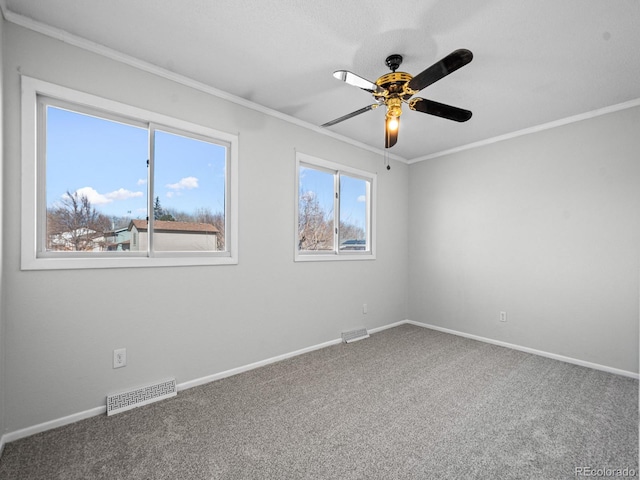 empty room with carpet floors, ornamental molding, and ceiling fan