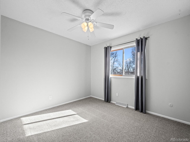 empty room with ceiling fan, carpet flooring, and a textured ceiling