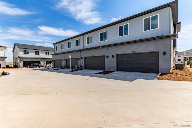 view of front of property featuring central AC unit, an attached garage, and concrete driveway