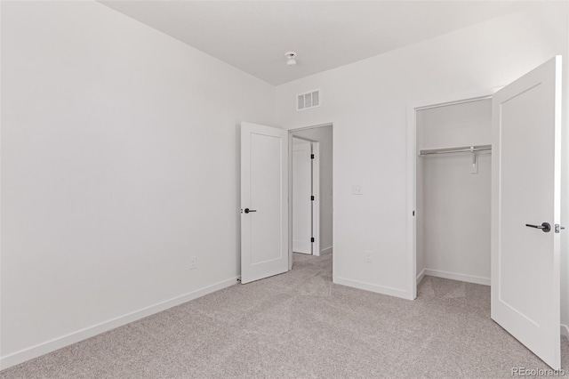 unfurnished bedroom with light carpet, baseboards, and a closet