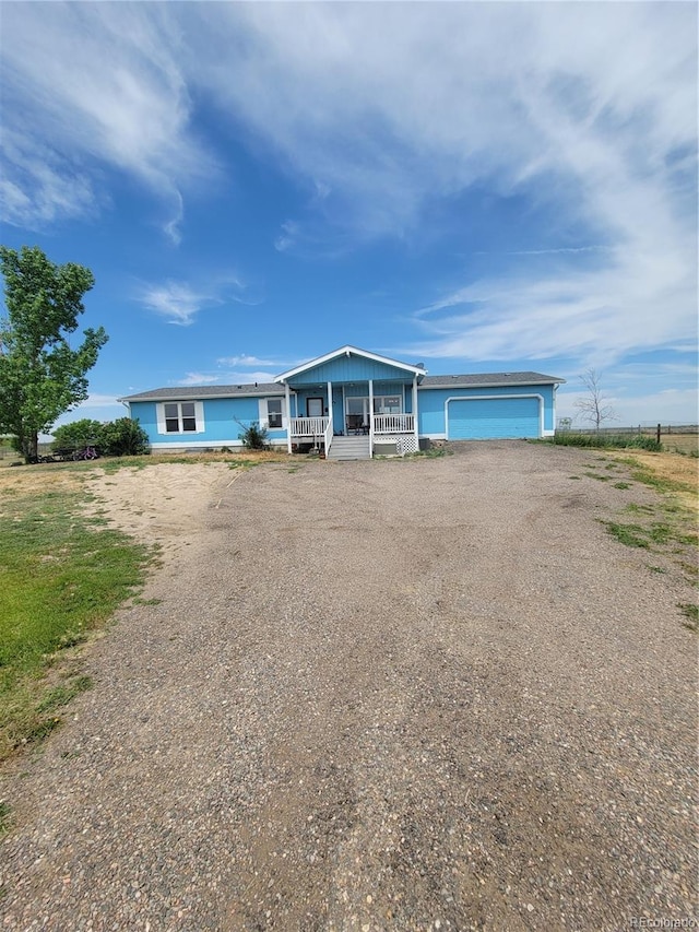 58117 E 42nd Dr, Strasburg, CO 80136 - view of front of house featuring dirt driveway, a garage, and covered porch