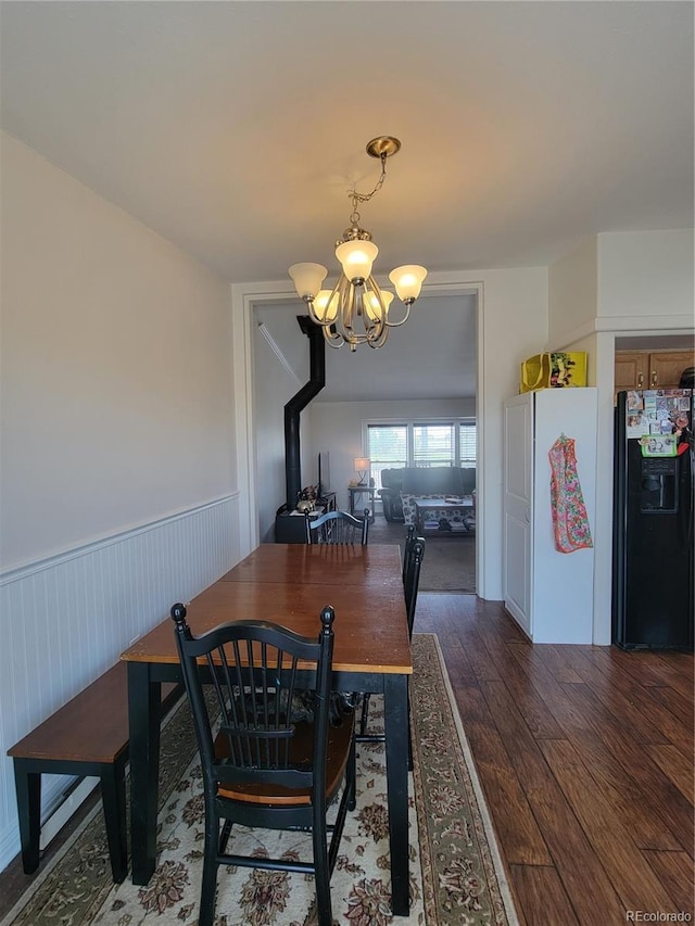 58117 E 42nd Dr, Strasburg, CO 80136 - dining area with a chandelier, dark wood-style flooring, and wainscoting