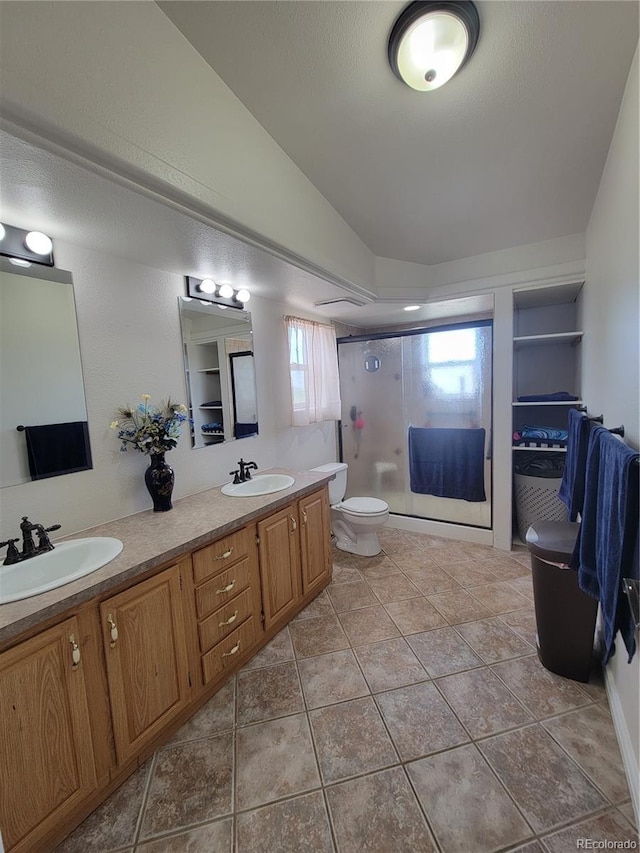 58117 E 42nd Dr, Strasburg, CO 80136 - full bath featuring lofted ceiling, double vanity, a stall shower, and toilet