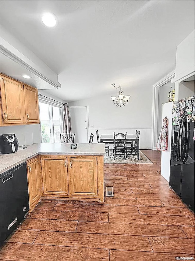 58117 E 42nd Dr, Strasburg, CO 80136 - kitchen with black appliances, dark wood-style floors, a peninsula, a chandelier, and light countertops