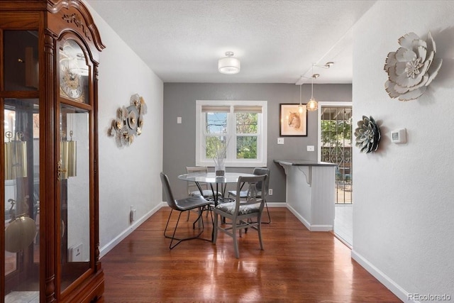 1568 S Osceola Way, Denver, CO 80219 - dining space featuring wood finished floors, baseboards, and a textured ceiling