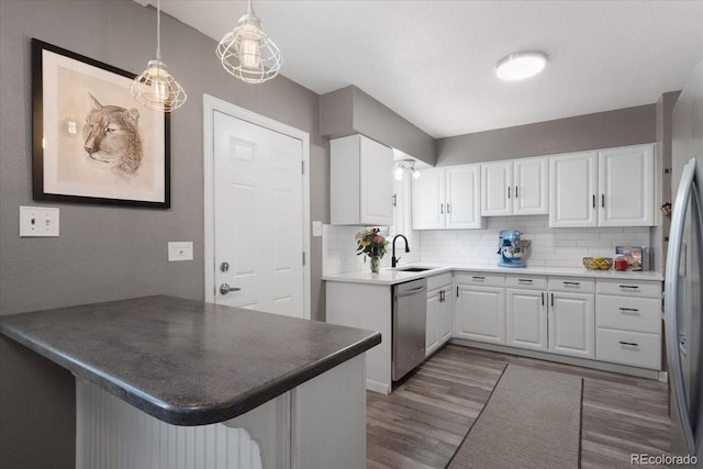 1568 S Osceola Way, Denver, CO 80219 - kitchen featuring appliances with stainless steel finishes, dark wood-type flooring, a sink, white cabinets, and decorative backsplash