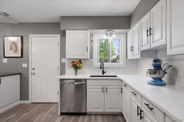 1568 S Osceola Way, Denver, CO 80219 - kitchen with stainless steel dishwasher, a sink, wood finished floors, and backsplash