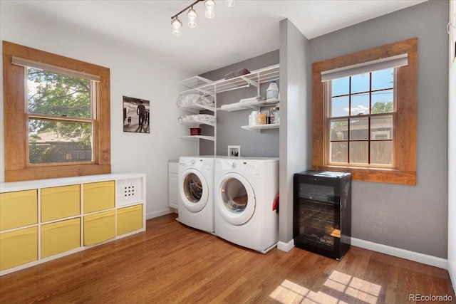 1568 S Osceola Way, Denver, CO 80219 - laundry room with washing machine and clothes dryer, wine cooler, baseboards, light wood-style floors, and rail lighting