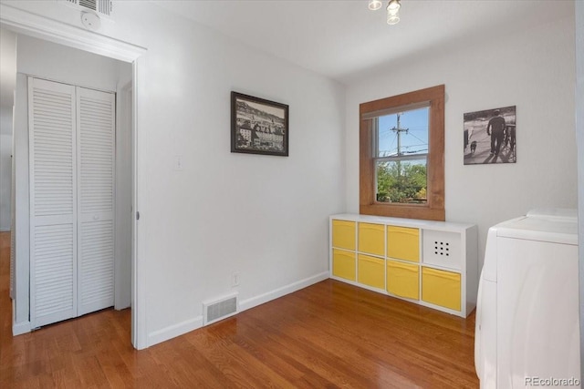 1568 S Osceola Way, Denver, CO 80219 - unfurnished bedroom featuring washer / clothes dryer, wood finished floors, baseboards, and a closet