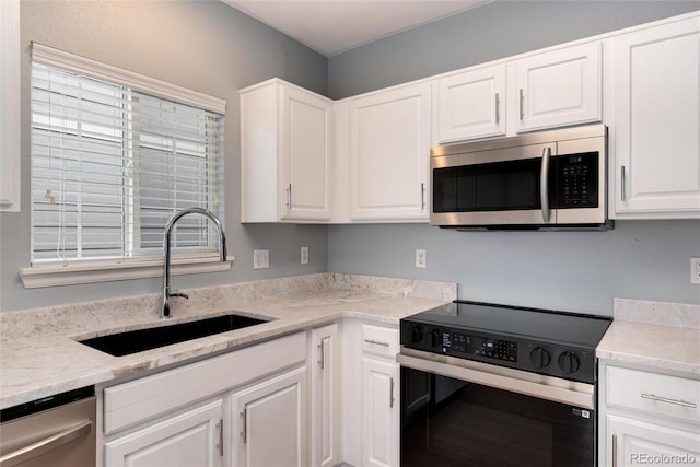 kitchen with white cabinetry, appliances with stainless steel finishes, and a sink