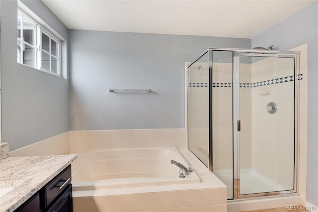 bathroom featuring a stall shower, vanity, and a bath