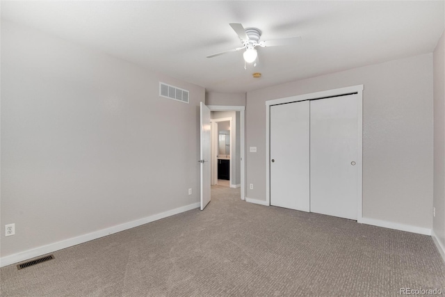 unfurnished bedroom with a closet, carpet flooring, visible vents, and baseboards