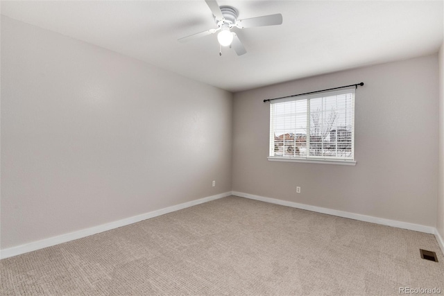 carpeted empty room with ceiling fan, visible vents, and baseboards