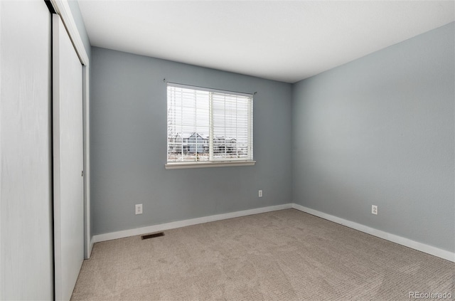 unfurnished bedroom featuring a closet, carpet flooring, visible vents, and baseboards