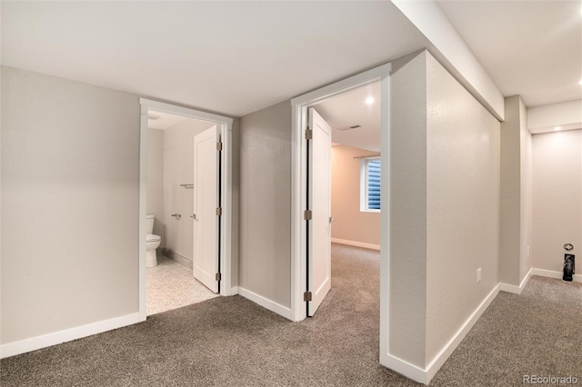 corridor with carpet and baseboards