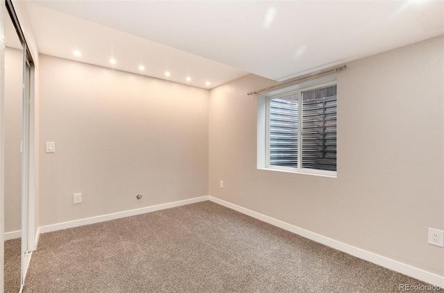 carpeted empty room featuring recessed lighting and baseboards