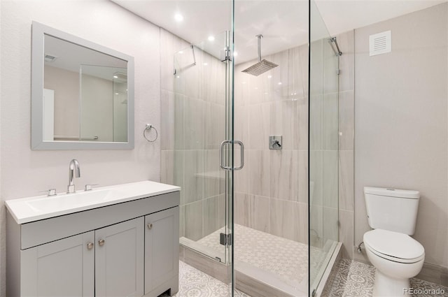 full bathroom featuring a stall shower, visible vents, vanity, and toilet