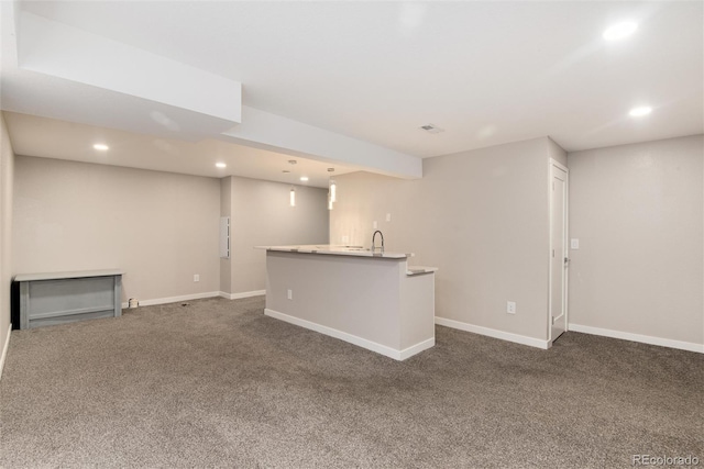 unfurnished living room featuring dark colored carpet, a sink, baseboards, and recessed lighting