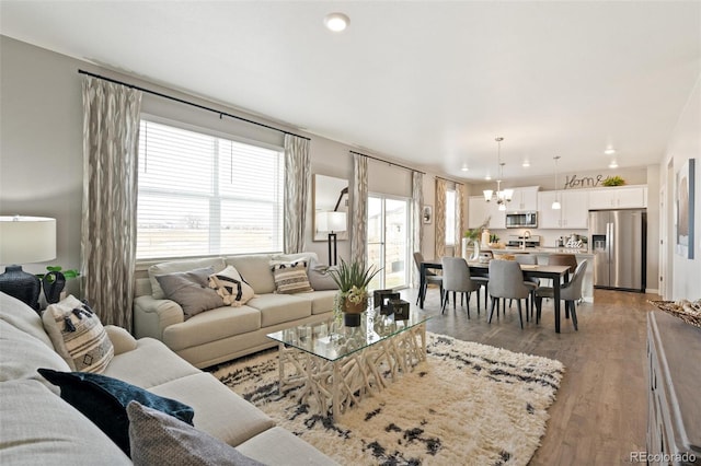 living room featuring a chandelier and light wood-type flooring