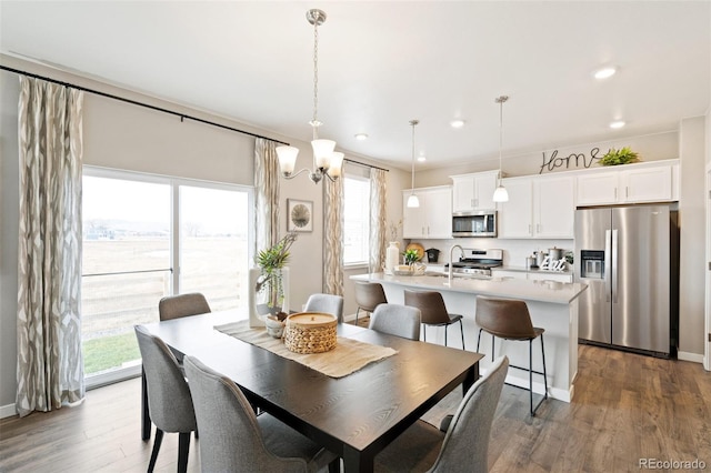 dining area featuring a chandelier, sink, dark wood-type flooring, and plenty of natural light