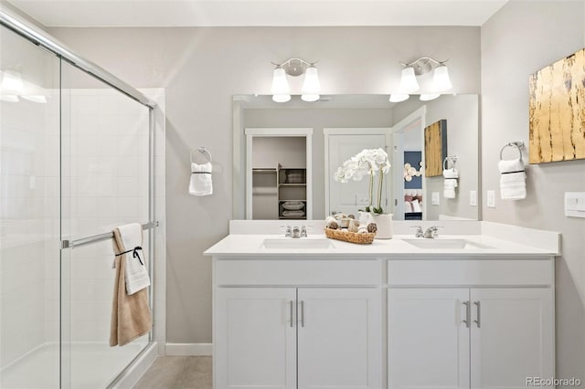 bathroom featuring a shower with door and vanity