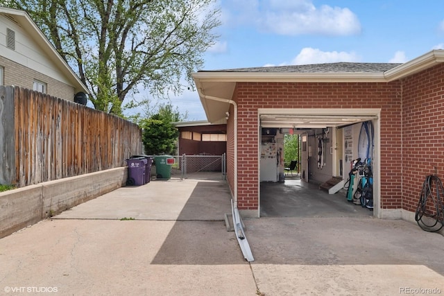 2792 S Stuart St, Denver, CO 80236 - view of patio featuring concrete driveway, a garage, and a gate