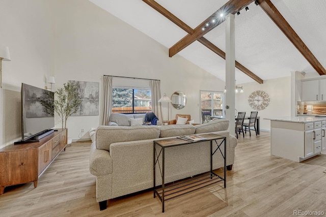 living room with light hardwood / wood-style flooring, high vaulted ceiling, and beamed ceiling