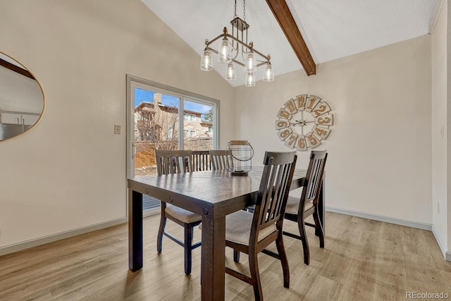 dining area featuring lofted ceiling with beams, a chandelier, and light hardwood / wood-style flooring