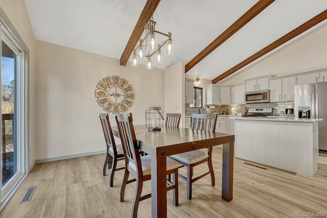 dining area featuring a chandelier, lofted ceiling with beams, and light wood-type flooring