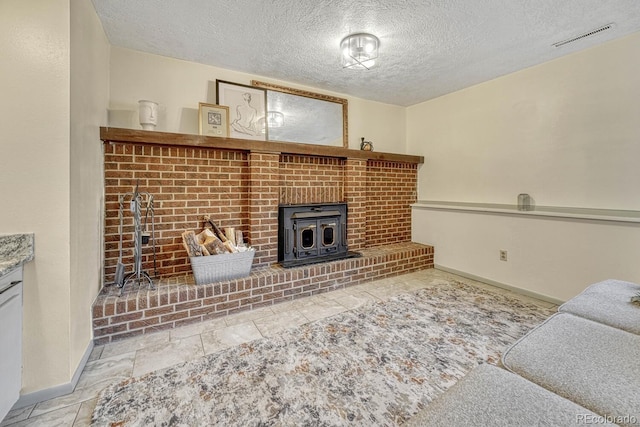 living room with a wood stove and a textured ceiling