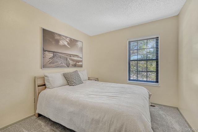 bedroom featuring a textured ceiling and carpet flooring