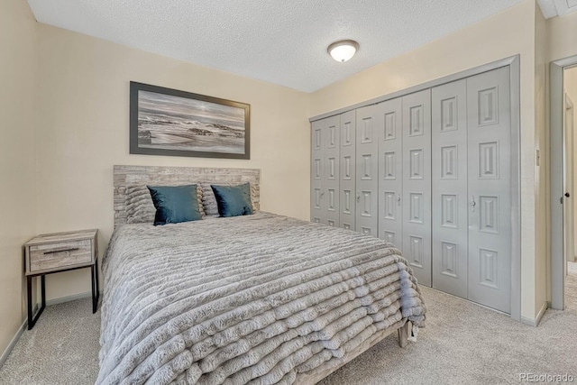 bedroom featuring light colored carpet, a closet, and a textured ceiling