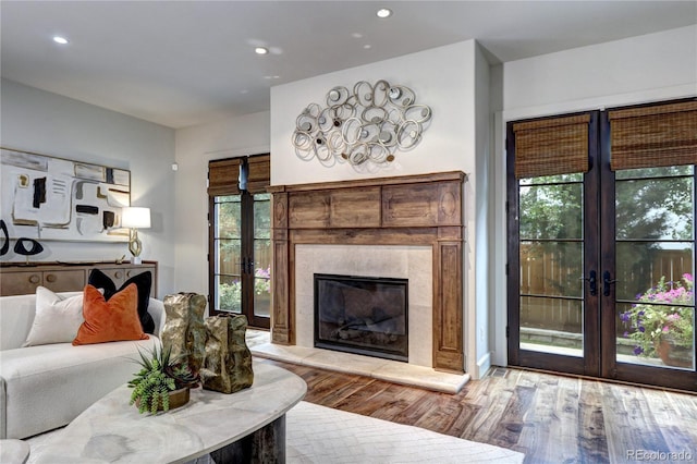 living room featuring french doors, wood finished floors, a fireplace, and recessed lighting