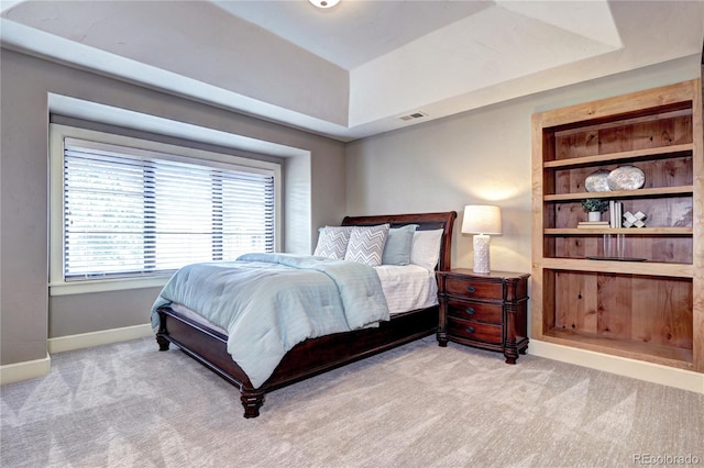 bedroom with baseboards, visible vents, carpet floors, and a tray ceiling