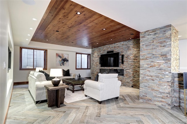 living area with wood ceiling, a stone fireplace, baseboards, and recessed lighting