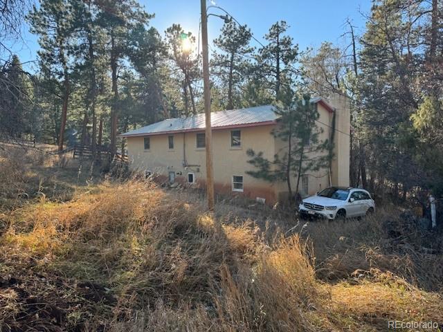 view of home's exterior with stucco siding and metal roof