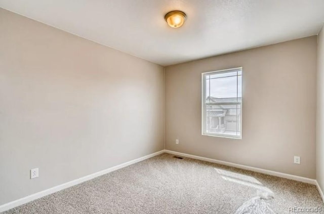 carpeted spare room with baseboards