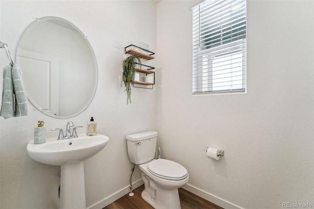 bathroom featuring a healthy amount of sunlight, toilet, and wood-type flooring